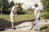 Bild: Eine Frau und ein Mann beim Minigolf.