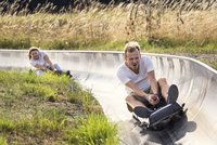 Bild: Ein Mann und eine Frau die auf der Sommerrodelbahn rodeln.