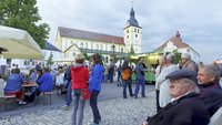 Bild: Menschen auf dem Marktplatz in Mitterteich bei einem Fest. Im Hintergrund ist die Kirche zu sehen.