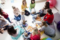 Bild: Eltern und Kinder, die in einem Kreis sitzen 