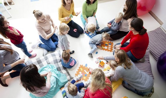 Bild: Eltern und Kinder, die in einem Kreis sitzen 